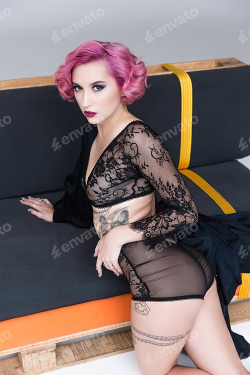 Preview: seductive tattoed girl in transparent lingerie posing on couch