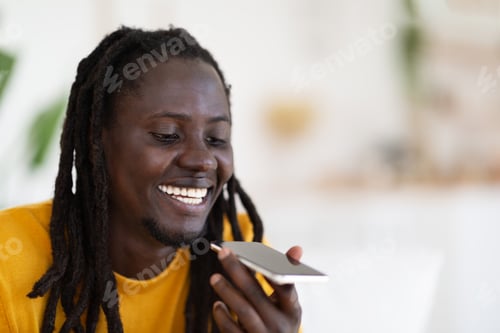 Preview: Closeup Shot Of Happy Black Guy Using Smartphone For Recording Voice Message