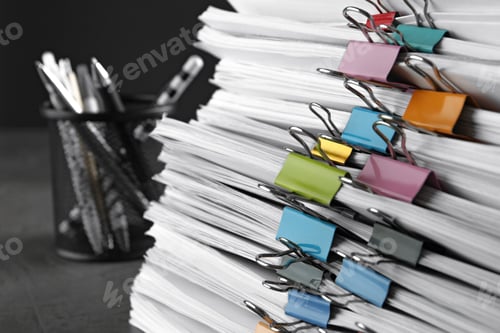 Preview: Stack of documents with binder clips on grey stone table, closeup view