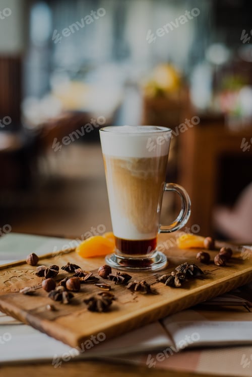 Preview: Close-up of a layered latte in a tall glass on a wooden board in a cafe