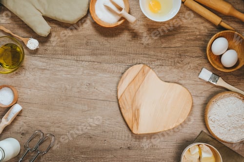 Preview: Heart shape wooden board near ingridients for prepairing dough