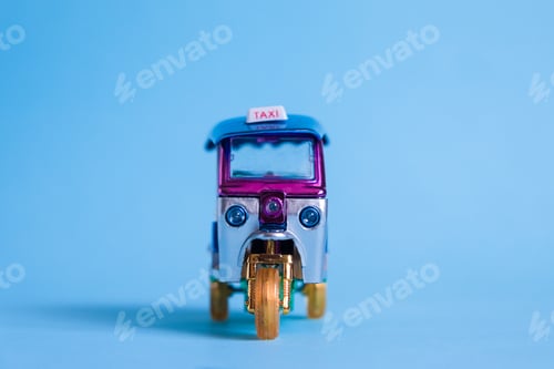 Preview: Model Toy tuk tuk isolated on blue background. Thai traditional taxi in Bangkok Thailand. Souvenir
