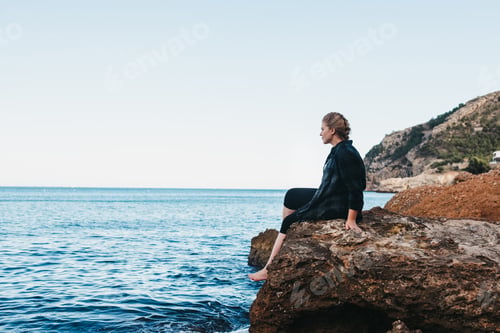 Preview: Woman sitting on seashore