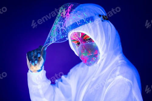 Preview: Portrait of woman doctor in protective clothes in ultraviolet neon light during coronavirus pandemic