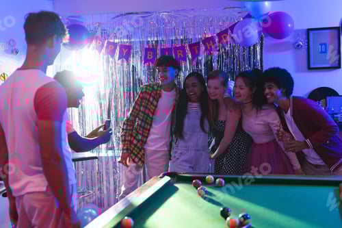 Preview: Teen friends posing for group photo at birthday party near pool table