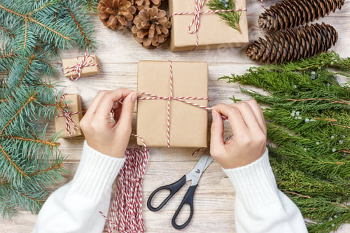 Preview: Process of packing boxes with Christmas gifts presents. Top view