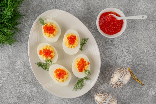 Preview: Easter appetizer. Deviled eggs topped with red caviar on a egg shaped plate. Festive snack