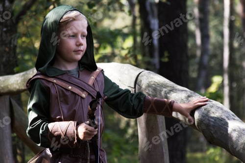 Preview: Portrait of a boy in a medieval costume holding a bow against a forest background
