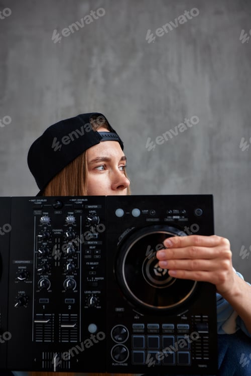 Preview: Close-up portrait of a young hip-hop girl in a black baseball cap with a visor back holding a dj