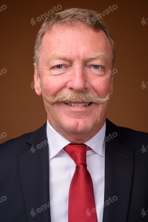 Preview: Face of happy senior businessman wearing suit and tie while smiling