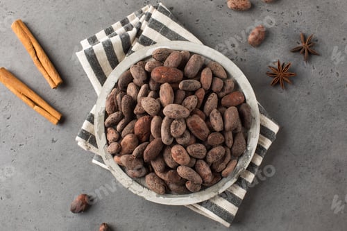 Preview: Cocoa beans in a plate on a dark gray background. Roasted cocoa beans.