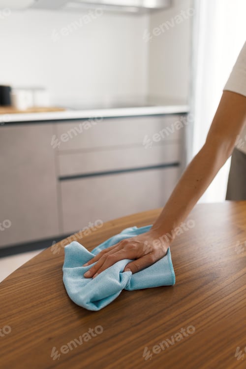 Preview: Woman cleaning the kitchen table with a cloth