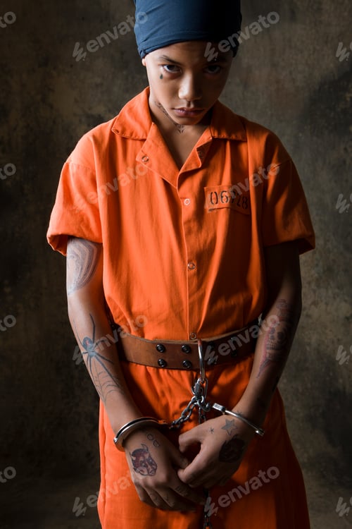 Preview: Studio portrait of staring boy in handcuffs and chains
