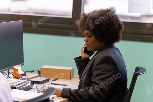 Preview: Woman multitasking with phone and computer.