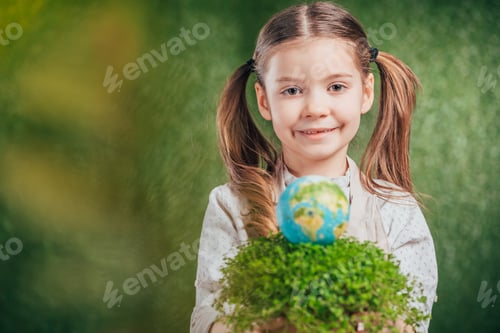 Preview: selective focus of smiling child with flower pot and globe model on blurred background, earth day