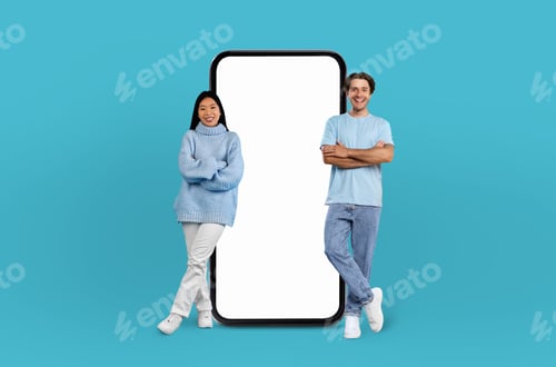Preview: Multiethnic couple stands adjacent to enormous smartphone with blank display