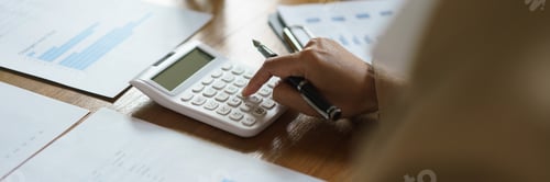 Preview: Businesswoman checking financial document of startup and calculate number with calculator in office