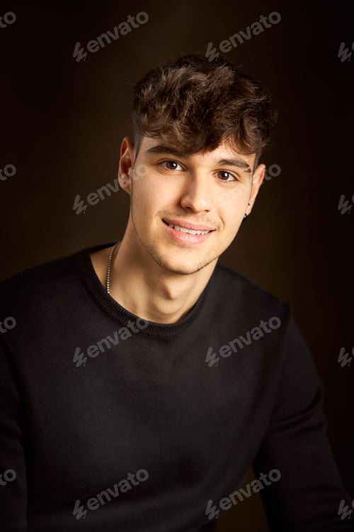 Preview: Young man smiling and posing for a studio portrait