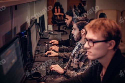 Preview: Team of teenage gamers plays in a multiplayer video game on pc in a gaming club.