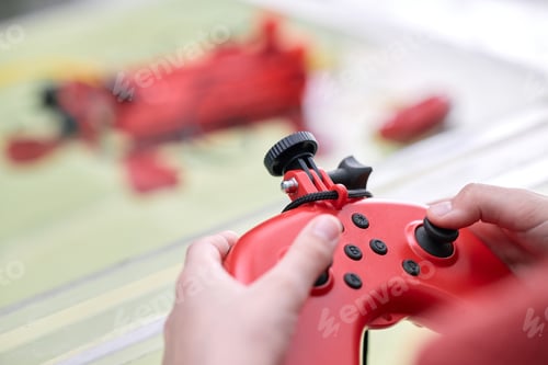 Preview: Playing Video Game with a Red Controller in Hand