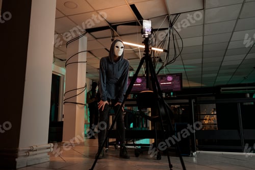 Preview: Online cybercriminal in anonymous mask recording live video