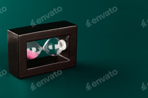 Preview: Sand hourglass on dark green paper background