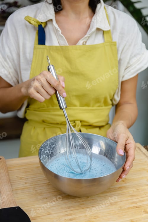 Preview: Woman mix almond milk, chia seeds and blue extrat of spirulina, natural color