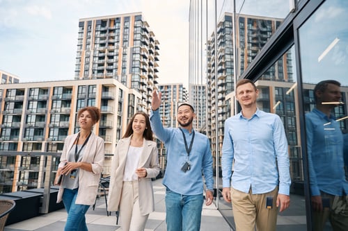 Preview: Team of coworkers strolling on office balcony at lunchtime