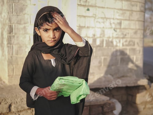 Child in Black Clothes Stands Outside by Brick Wall