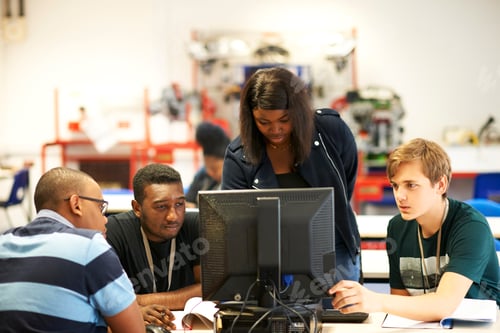 Preview: Male and female higher education students looking at computer in college classroom