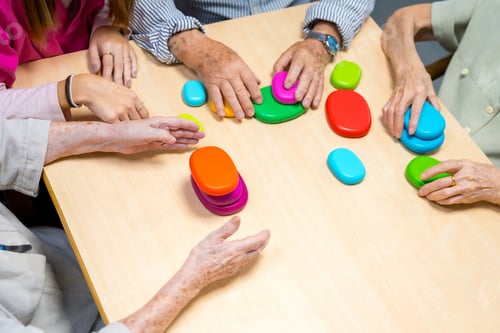 Preview: Hands of aged people playing board game indoors