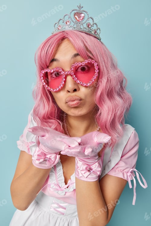 Preview: Be my valentine. Surprised pink haired woman keeps lips folded blows air kiss at camera expresses