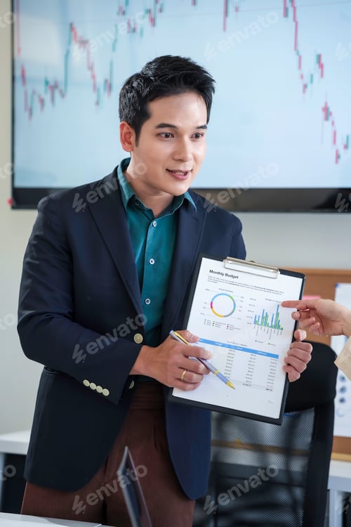 Preview: Asian businessman presenting monthly budget with charts and graphs on clipboard