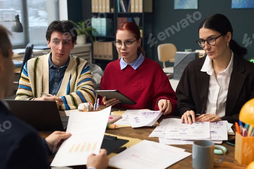 Preview: Young Man and Two Young Women Discussing Business Strategy
