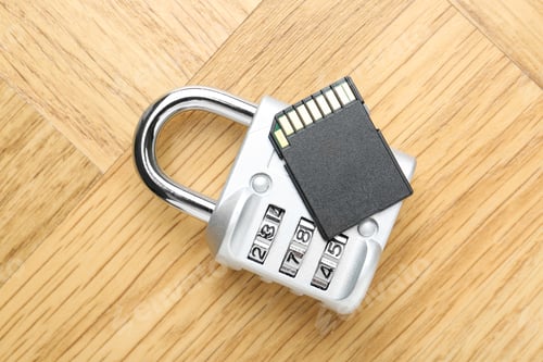Preview: SD memory card and combination padlock on light wooden table, top view
