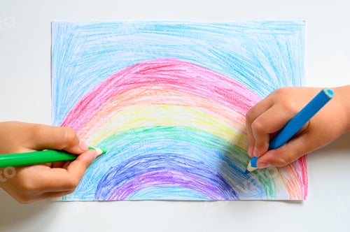 Preview: kid's hands together draw a rainbow colored pencils on white background