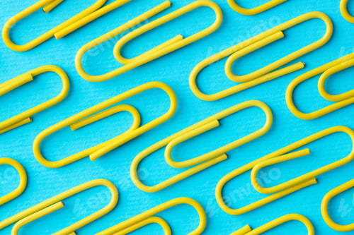 Preview: Many paper clips on light blue background, flat lay