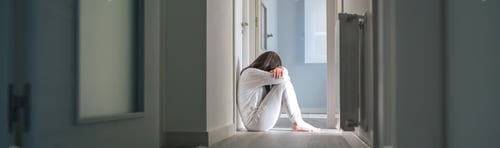 Preview: Woman in pajamas sitting on the floor of a mental health center