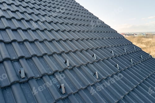 Preview: Closeup snow guard for safety in winter on house roof top covered with ceramic shingles. Tiled