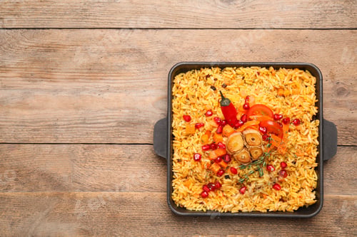 Preview: Tasty rice pilaf with vegetables on wooden table, top view. Space for text