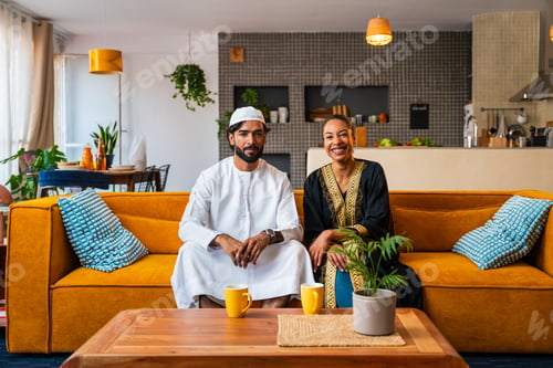 Preview: Happy beautiful young arab couple with emirati clothing together at home