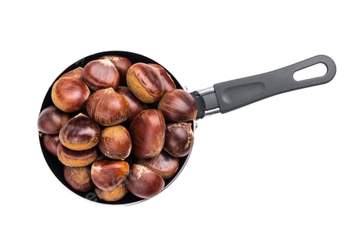 Preview: Raw chestnuts in rustic skillet ready for cooking isolated on white background