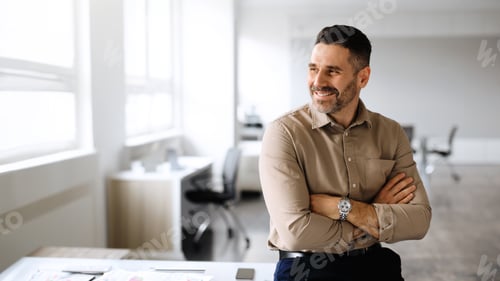 Preview: Successful middle aged businessman posing with crossed hands, looking away and smiling, copy space