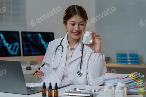 Visualização: Médica asiática sorrindo e segurando um frasco de remédio enquanto lê o relatório médico com laptop com