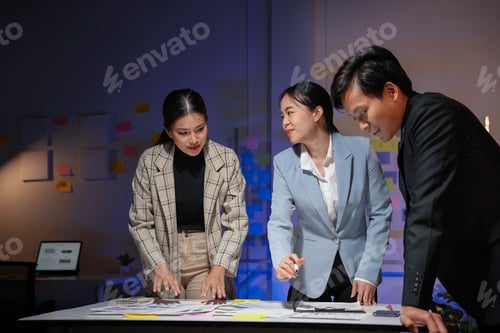 Preview: Team of asian businesspeople working late in the office, collaborating on a project
