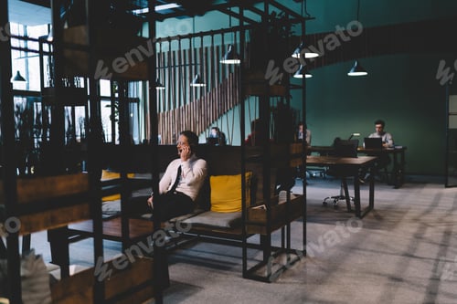 Preview: Male employees working in spacious office with hanging lamps