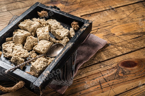 Preview: Turkish Halva with sunflower seeds and honey in wooden tray. Wooden background. Top view. Copy space