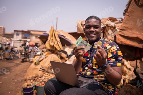 Preview: African boy at the market holding FCFA francs and a Bitcoin coin, cryptocurrencies in africa