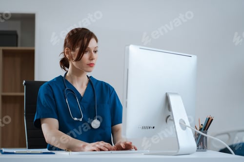 Preview: Doctor working with laptop computer and writing on paperwork.
