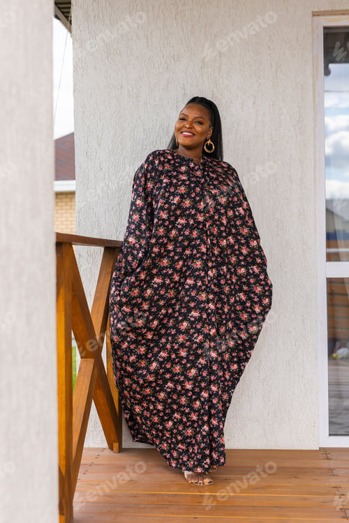 Preview: African american woman relaxing and enjoying sun while standing at terrace or balcony at sunlight at